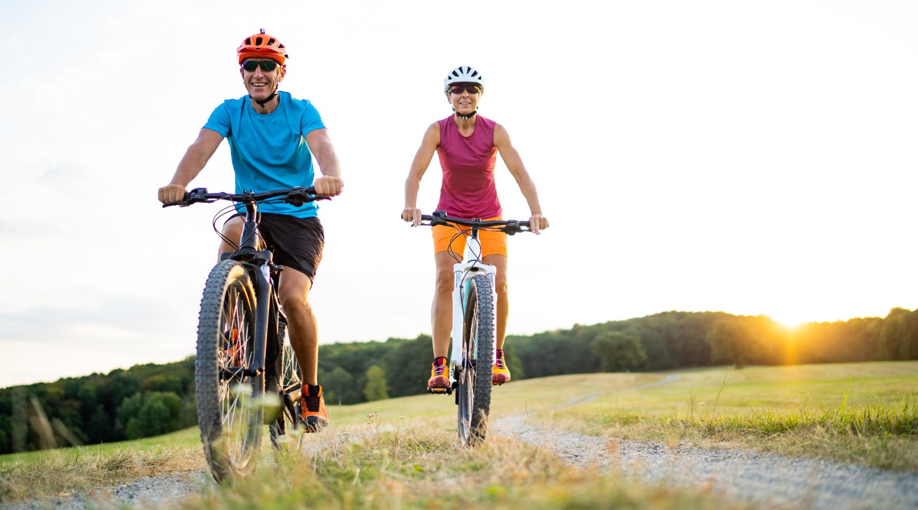Older man and woman cycling outdoors