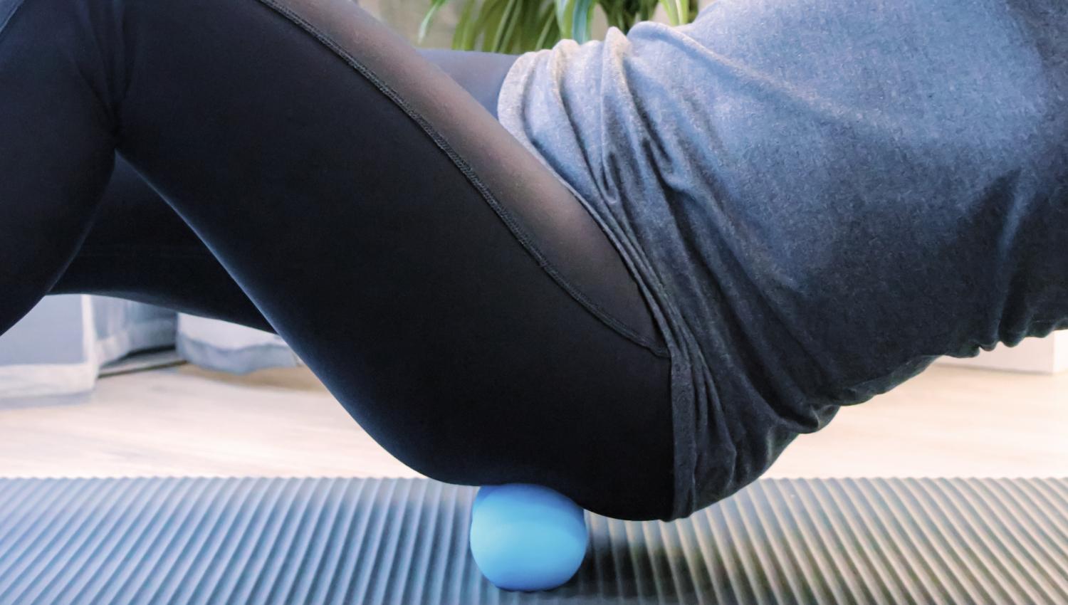 Woman using ball massager on her glutes
