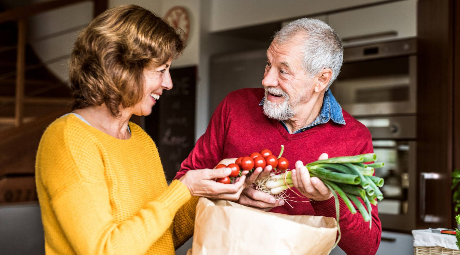 Senior couple preparing food in the kitchen. An old man and woman inside the house.