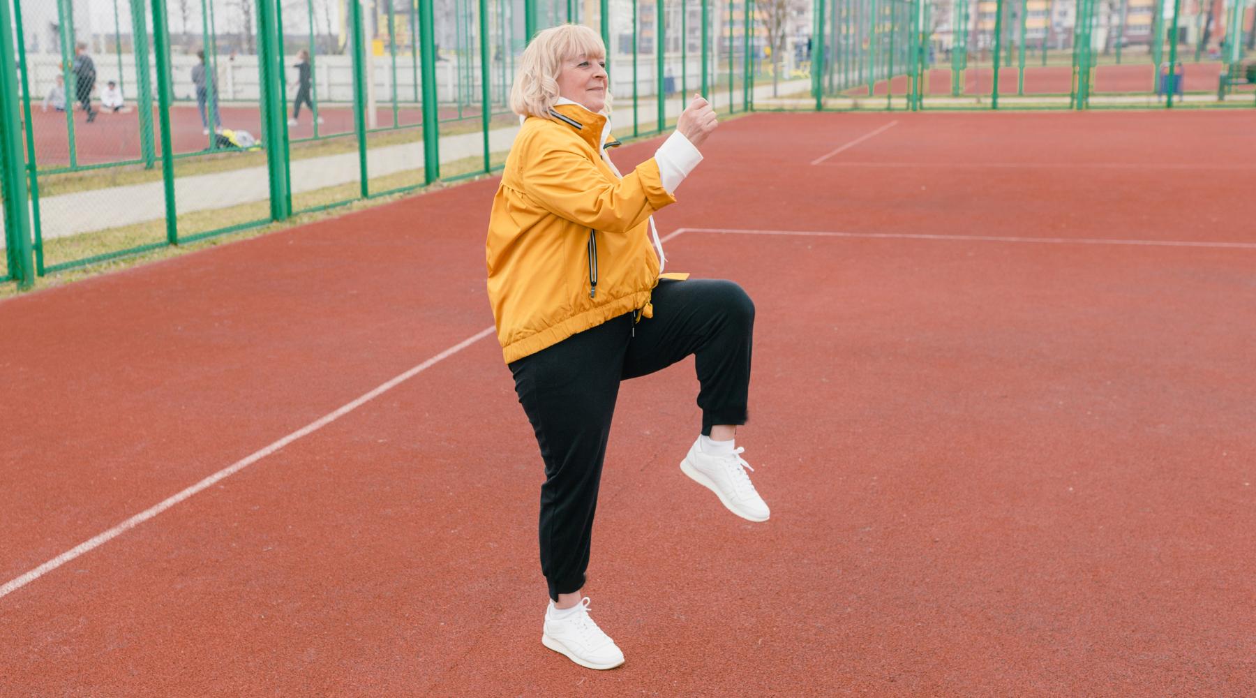 Elderly woman stretching and warming up outdoors