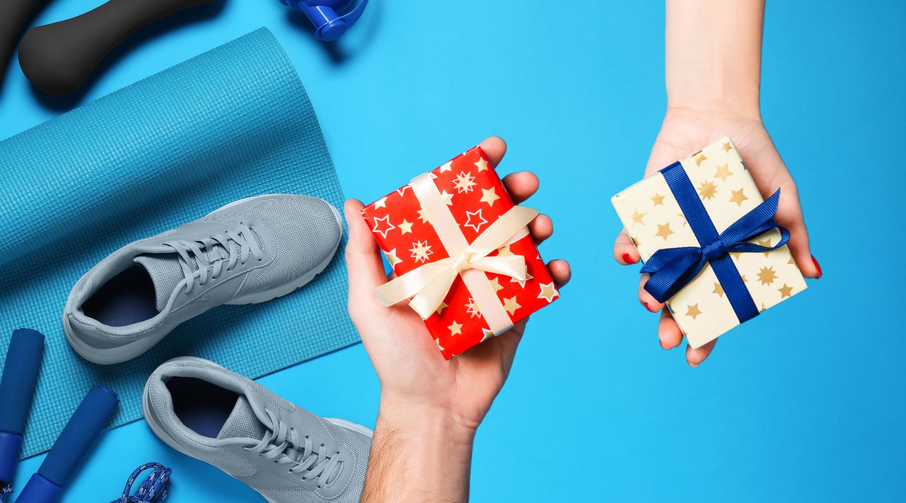 Fitness equipment. Man's hand holding out a gift. Woman's hand holding out a gift