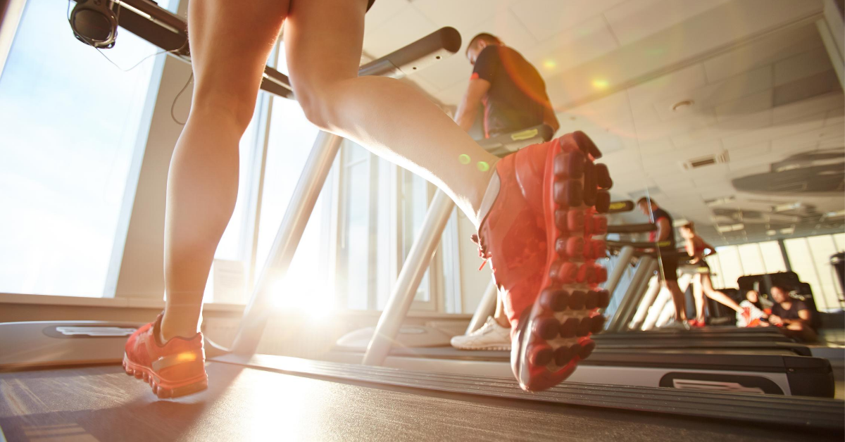 Shot of person's legs while they run on a treadmill indoors.