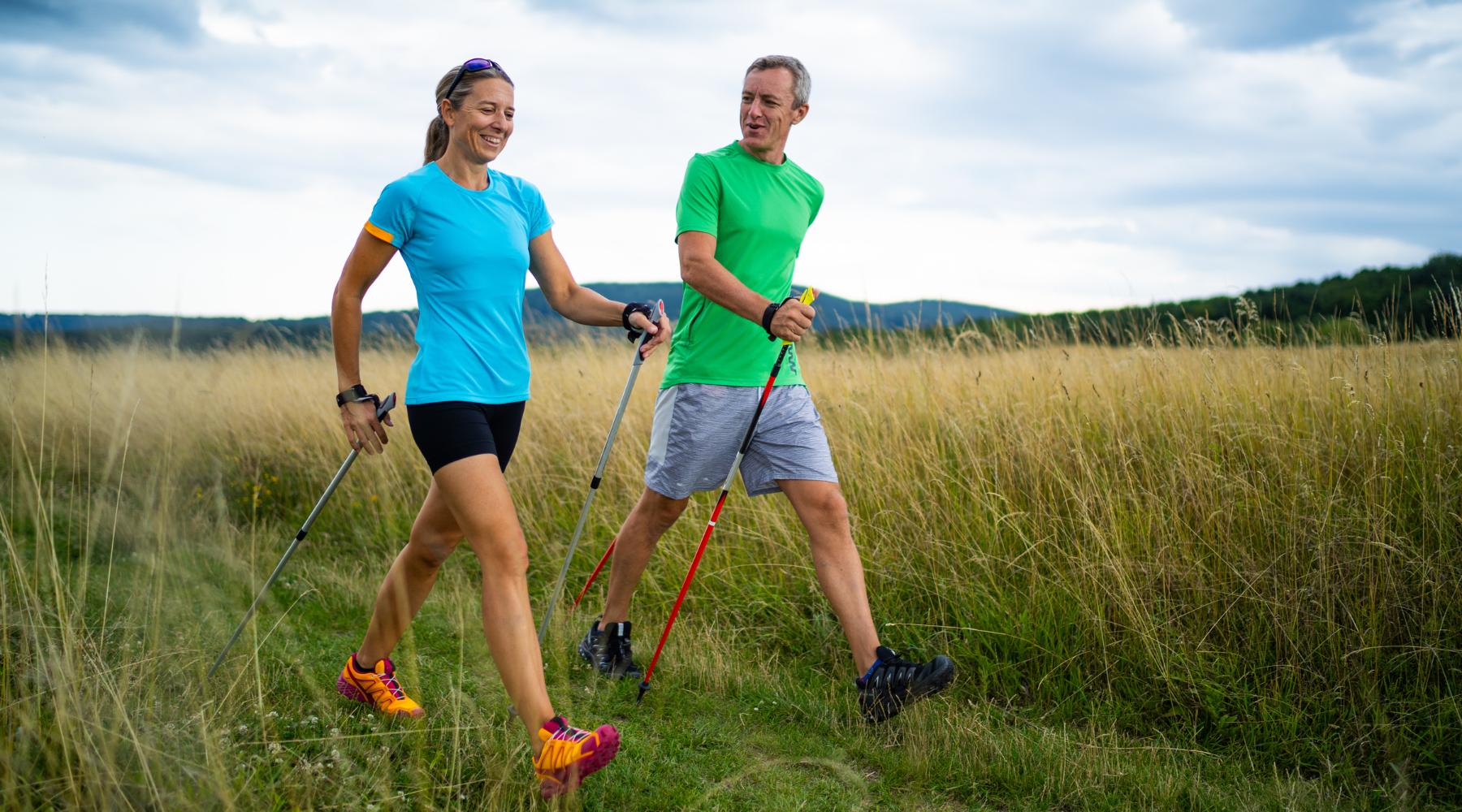 Couple Nordic walking on a grass field