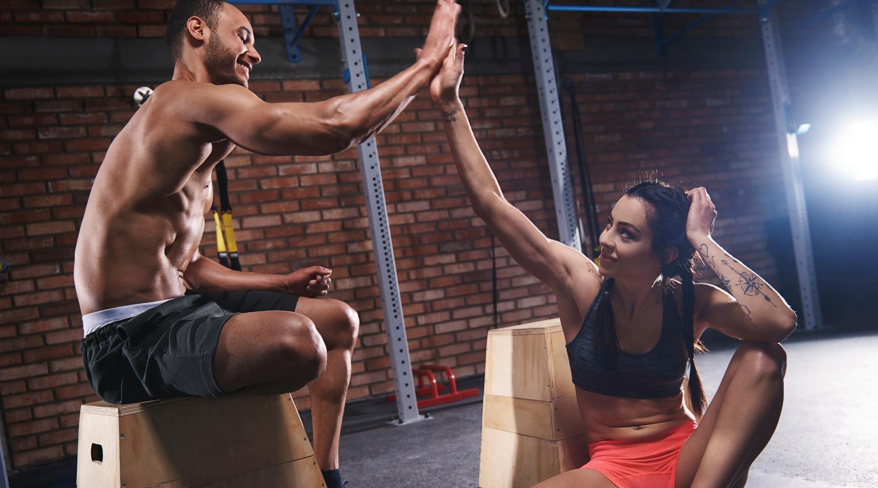 Fit man and woman highfiving after CrossFit workout