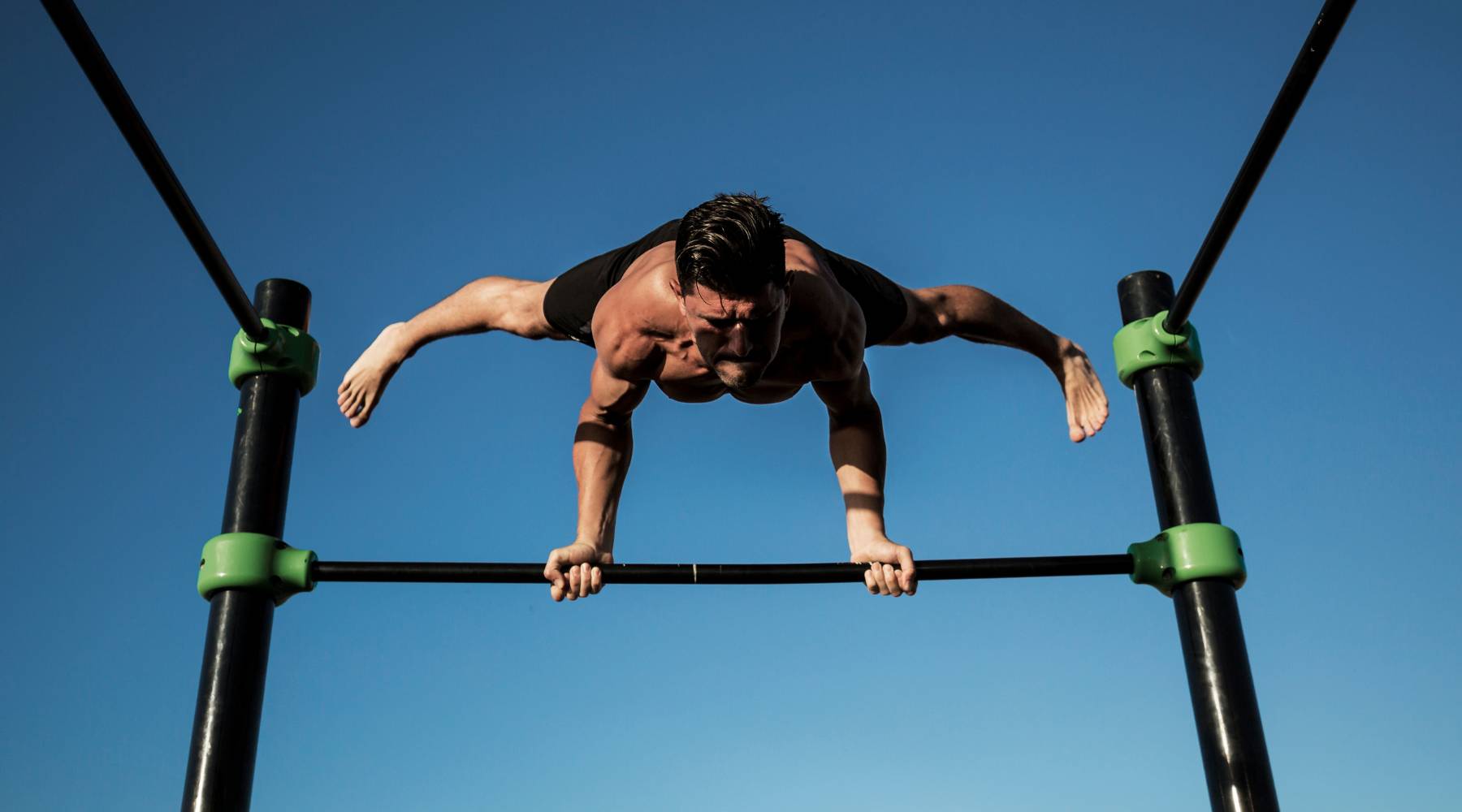 Athletic man doing short burst of exercise outdoors calisthenics workout