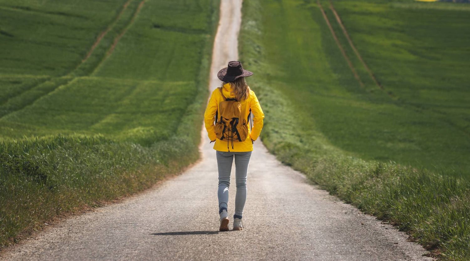 Woman in hiking gear walking down dirt road