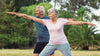 Senior couple doing yoga pose outdoors