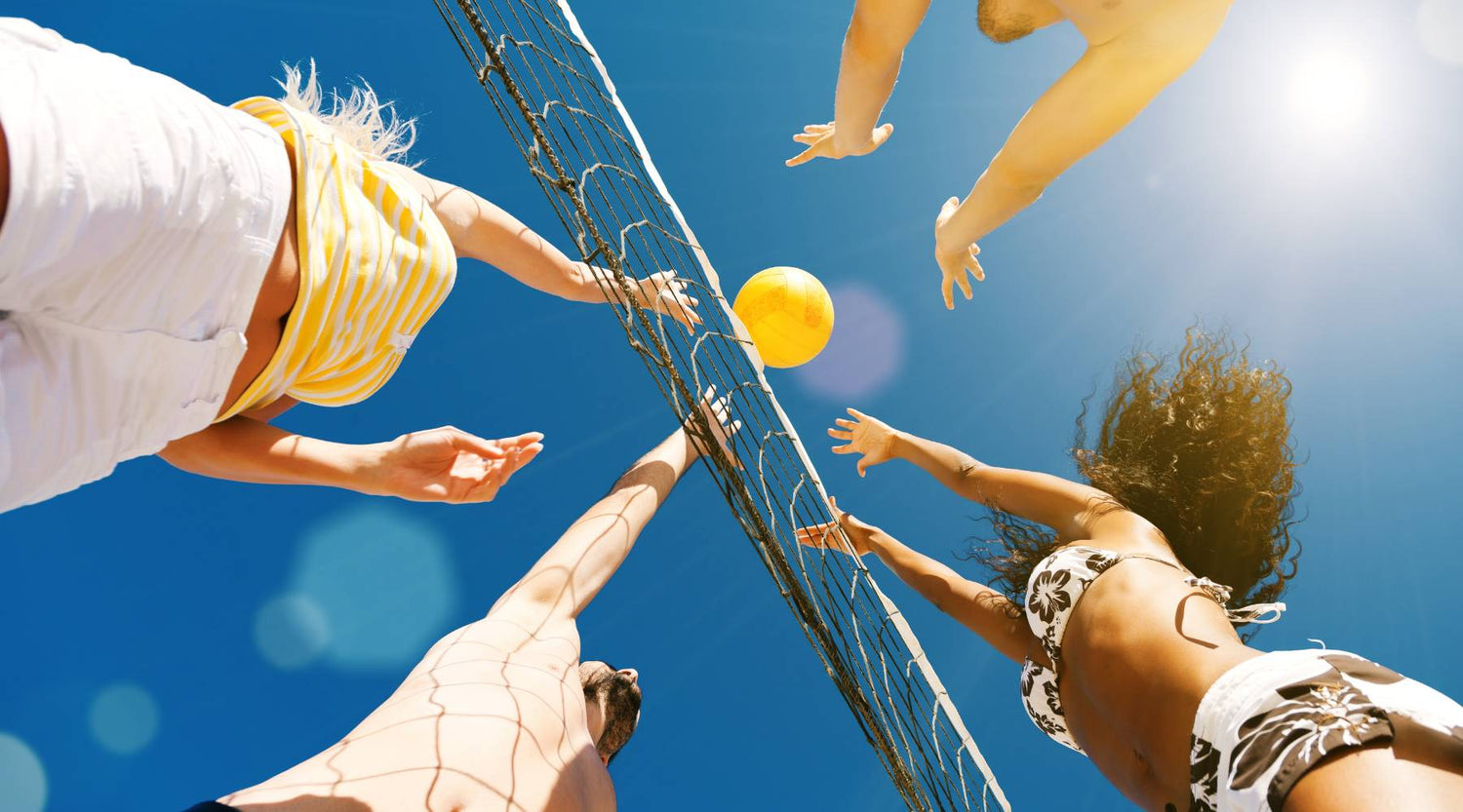 Young people playing beach volleyball