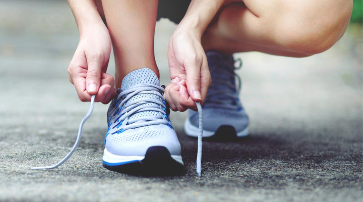 Woman lacing up walking shoes outdoors
