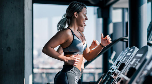 Attractive young woman burning calories cardio workout treadmill gym