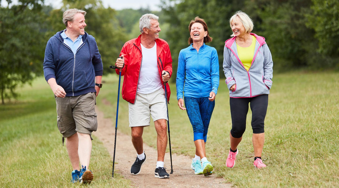 Two senior couples walking outdoors on nature trail