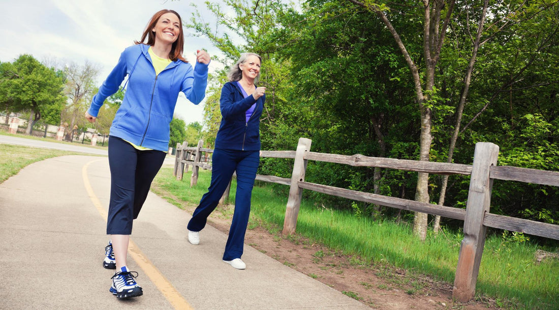 Two women power walking outdoors in a rural area