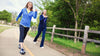 Two women power walking outdoors in a rural area