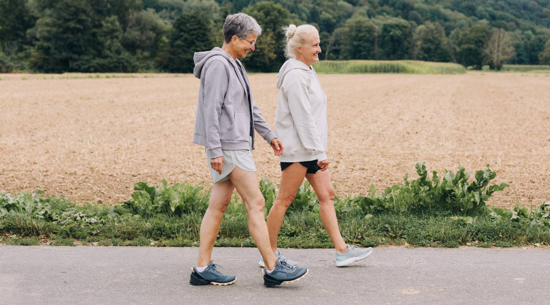 Two older women walking outdoors for health and longevity