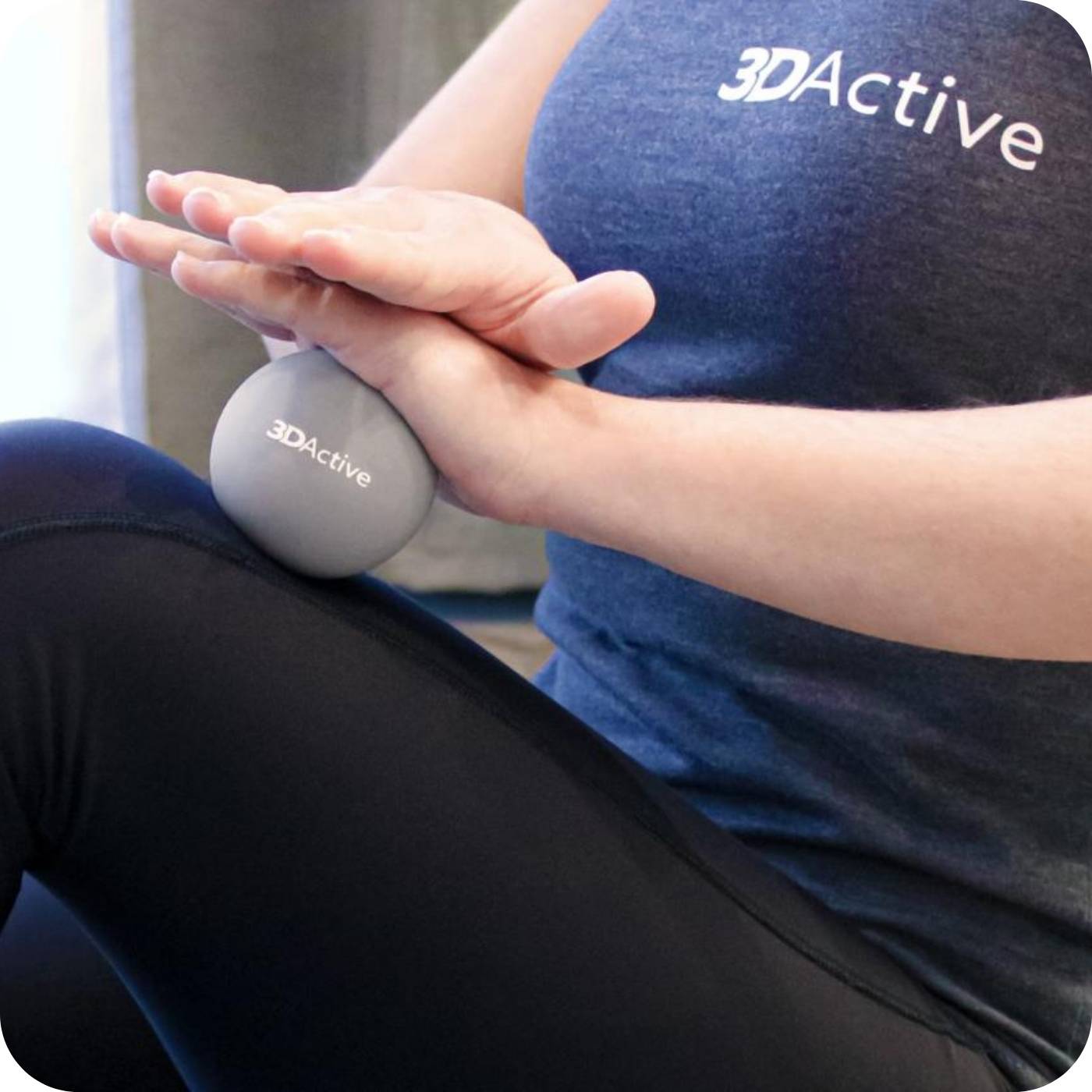 woman using her 3dactive massage ball to massage her leg