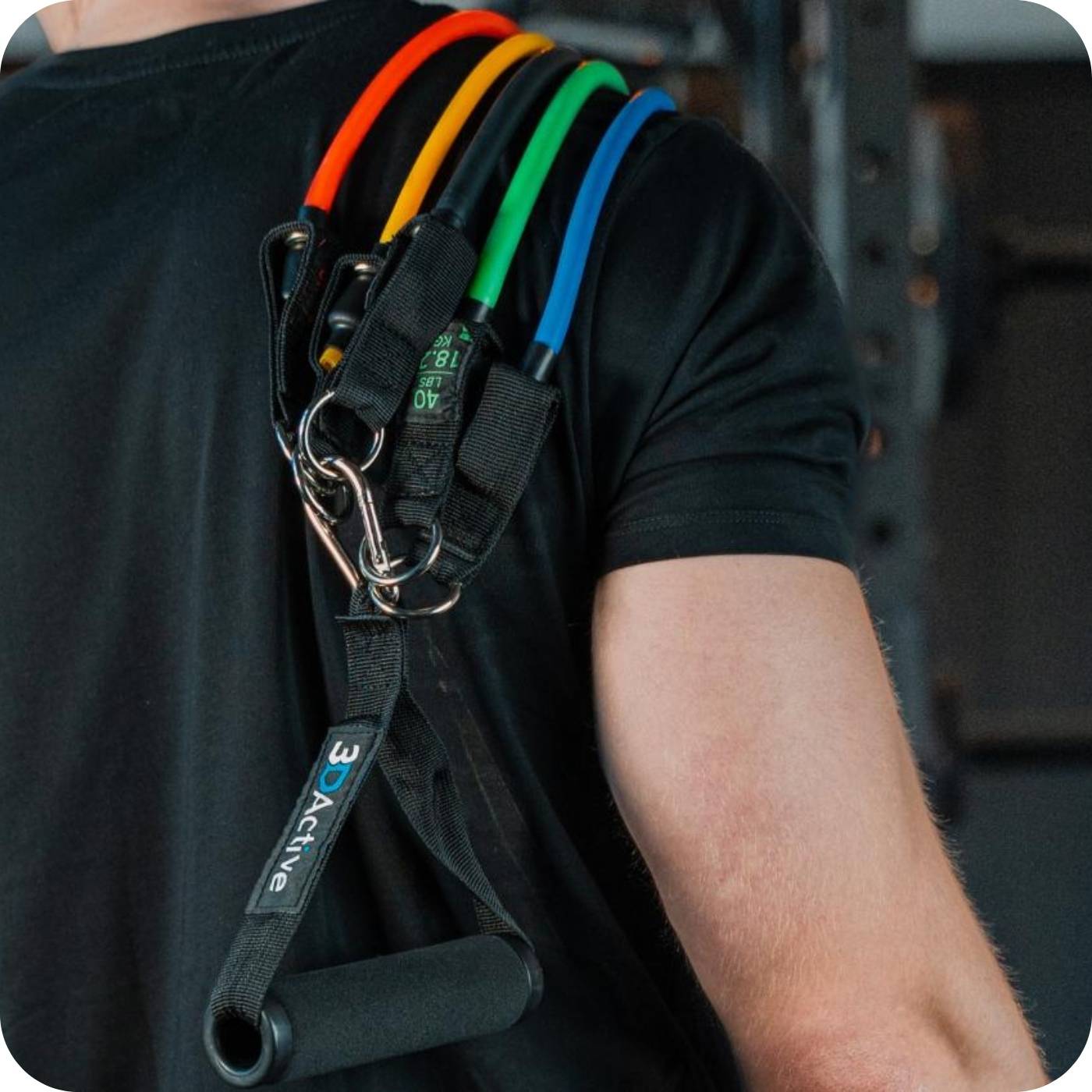 man with his resistance bands with handles set over his shoulder ready to workout