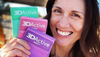 Woman smiling while holding color set of 3DActive booty bands next to her face