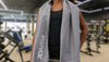 Woman with 3DActive Extra Large Microfiber Gym Towel over her shoulders at the gym